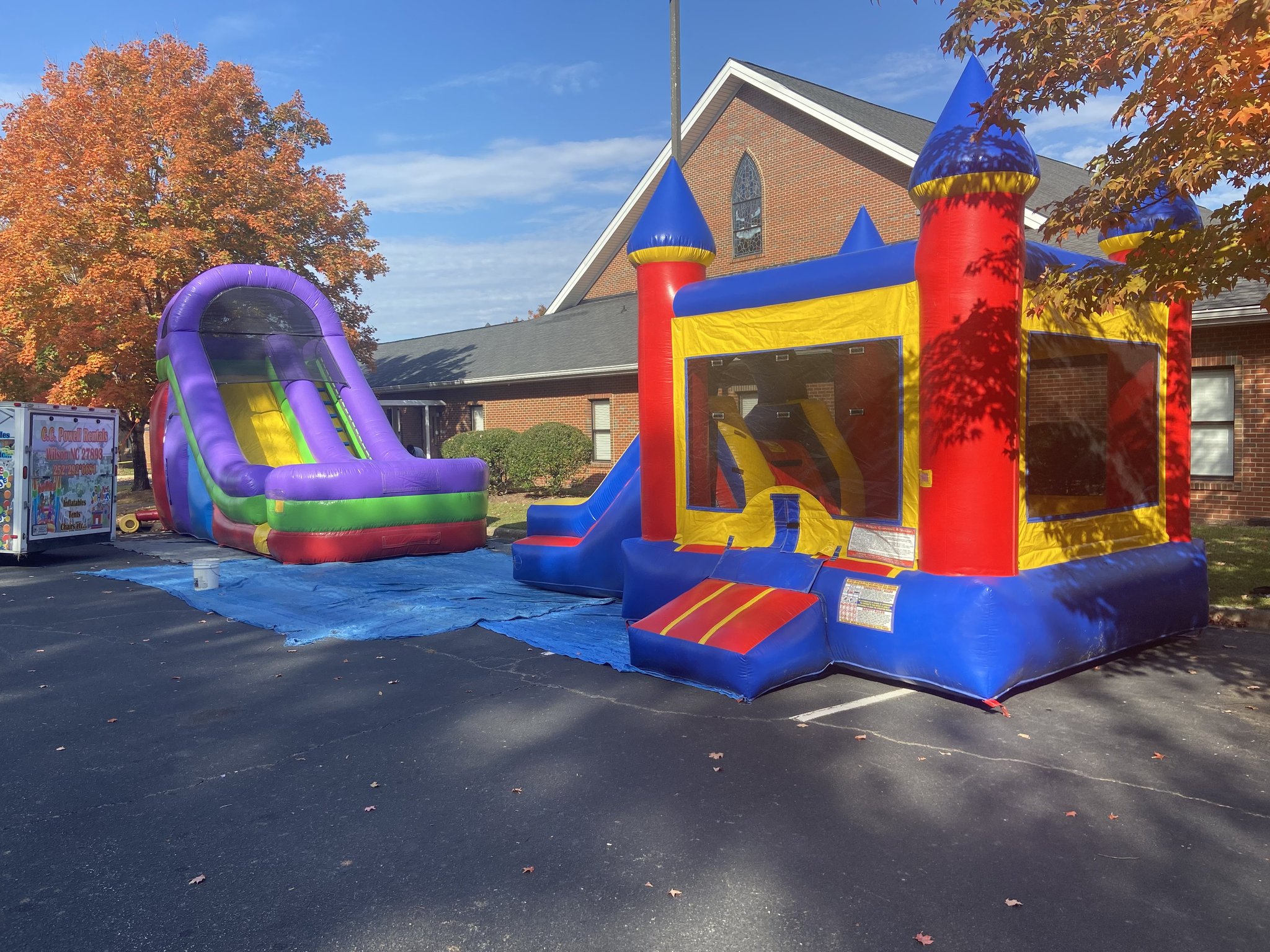 Inflatable bounce house with slide set up outside